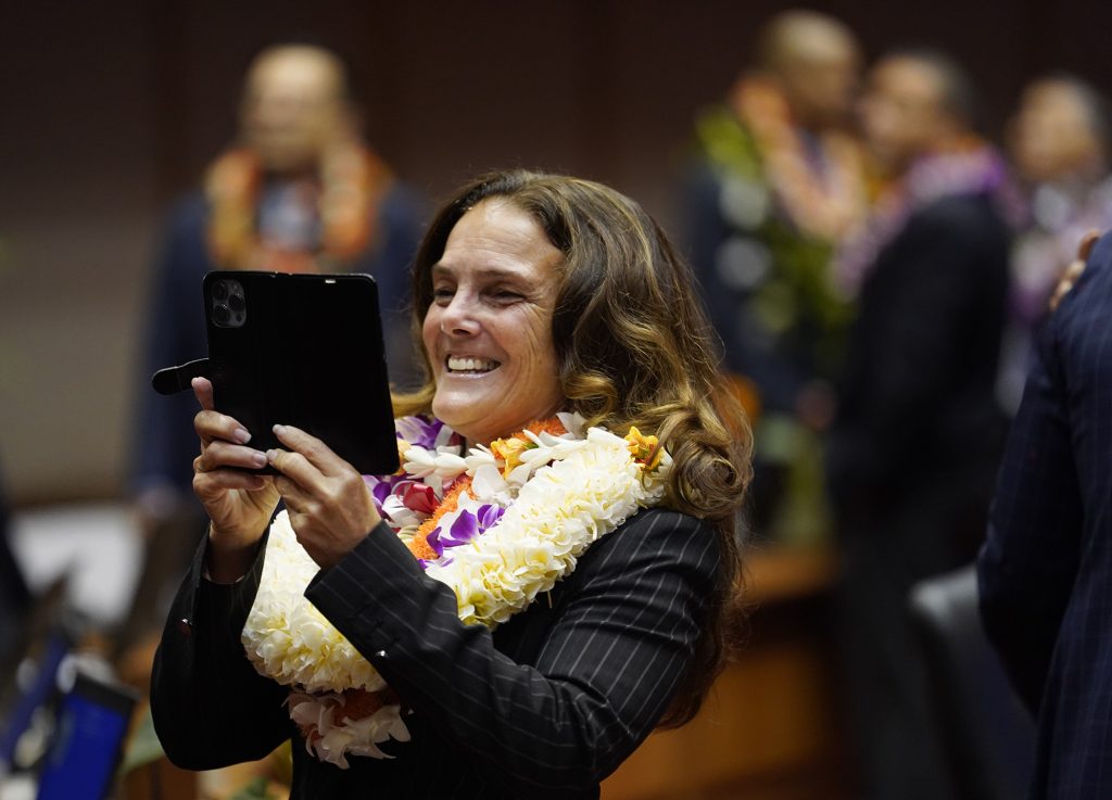 The House of Representatives majority whip Amy Perruso photographs some colleagues before opening the legislative session Wednesday, Jan. 17, 2024, in Honolulu. (Kevin Fujii/Civil Beat/2024)