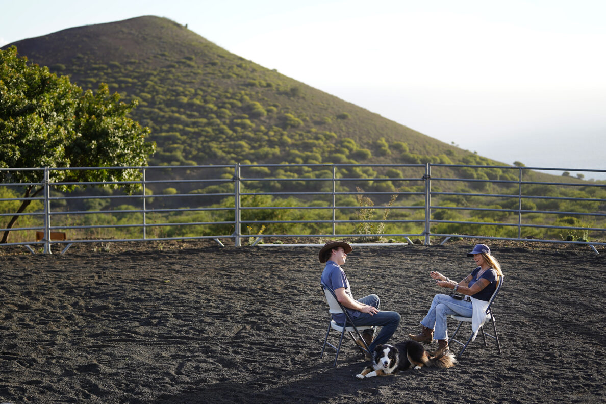 Garrett Higgins works with Paige Deponte Director Kulia I Ka Nu'u Spirit Horse Ranch Friday, Nov. 8, 2024, in Kula. Blue sits at their feet. (Kevin Fujii/Civil Beat/2024)