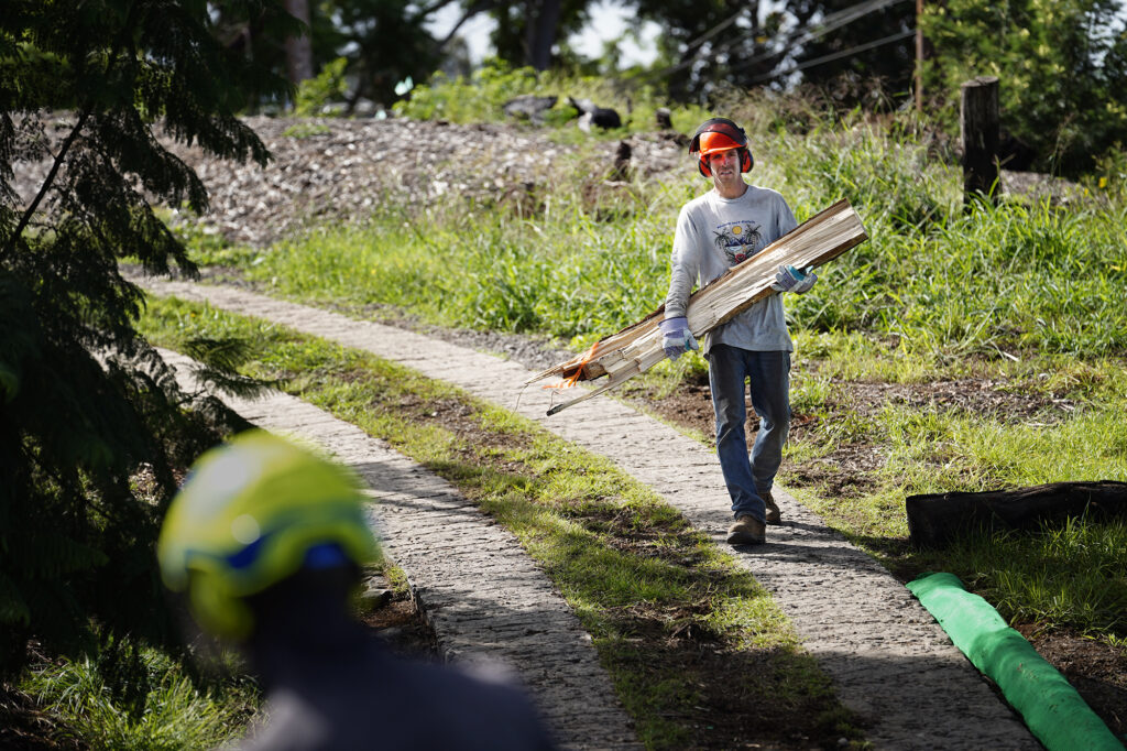 Mālama Kula Executive Director Kyle Ellison carries wood for chipping in Maui’s Upcountry Friday, Nov. 8, 2024, in Kula. This mostly residential, non-tourist area was hit with a fire the same day as Lahaina on Aug. 8, 2023. Before the fires, some residents tossed their green waste in the Pōhakuokalā Gulch. This added more fuel to the Aug. 8 fire. (Kevin Fujii/Civil Beat/2024)