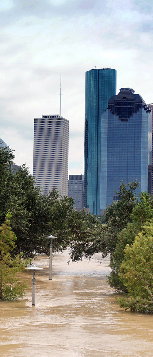 flooding of a city street with street lamps almost submerged and high-rise office buildings in the background