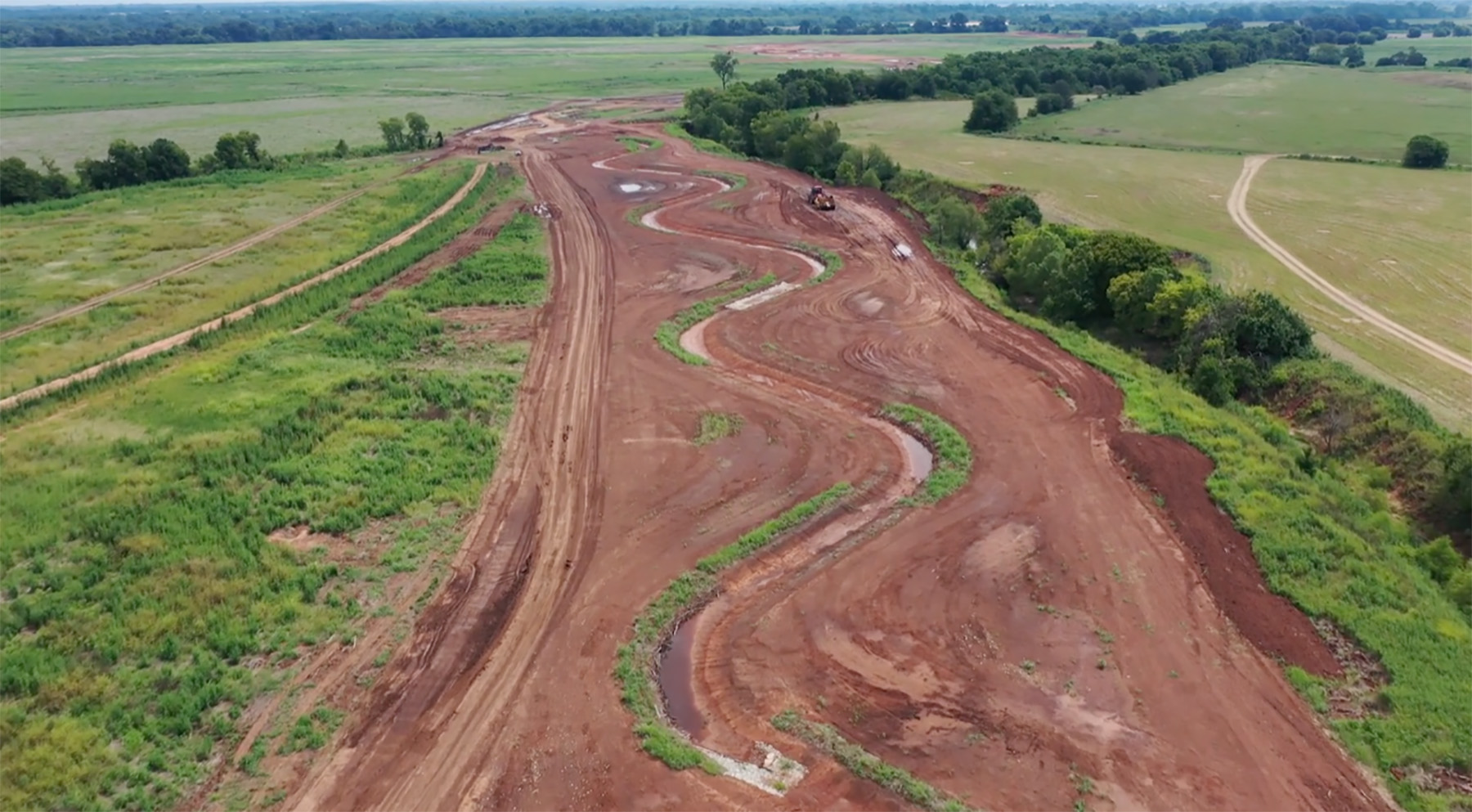 curvy stream bed with plantings and trees on each side of it