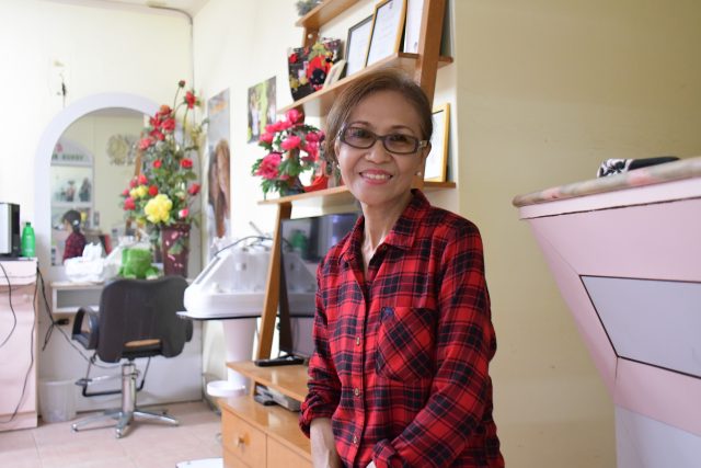 Bing sits in the hair salon where she's worked for 29 years in Garapan, Saipan. Photo taken August 2022.