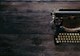 ANTIQUE TYPEWRITER ON WOODEN DESK