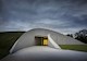 Curved walls lead to the main entrance. (Image courtesy of Hufton + Crow)