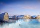 heat rises off the surface of a geothermal-heated lagoon while a series of buildings surround the waters edge.