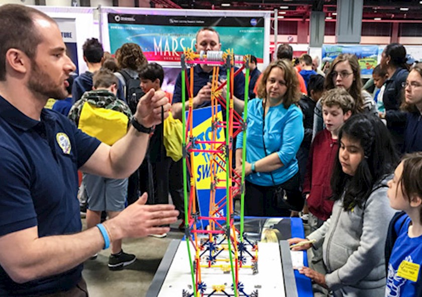 An ASCE member volunteering at a science and engineering festival for k-12 students.