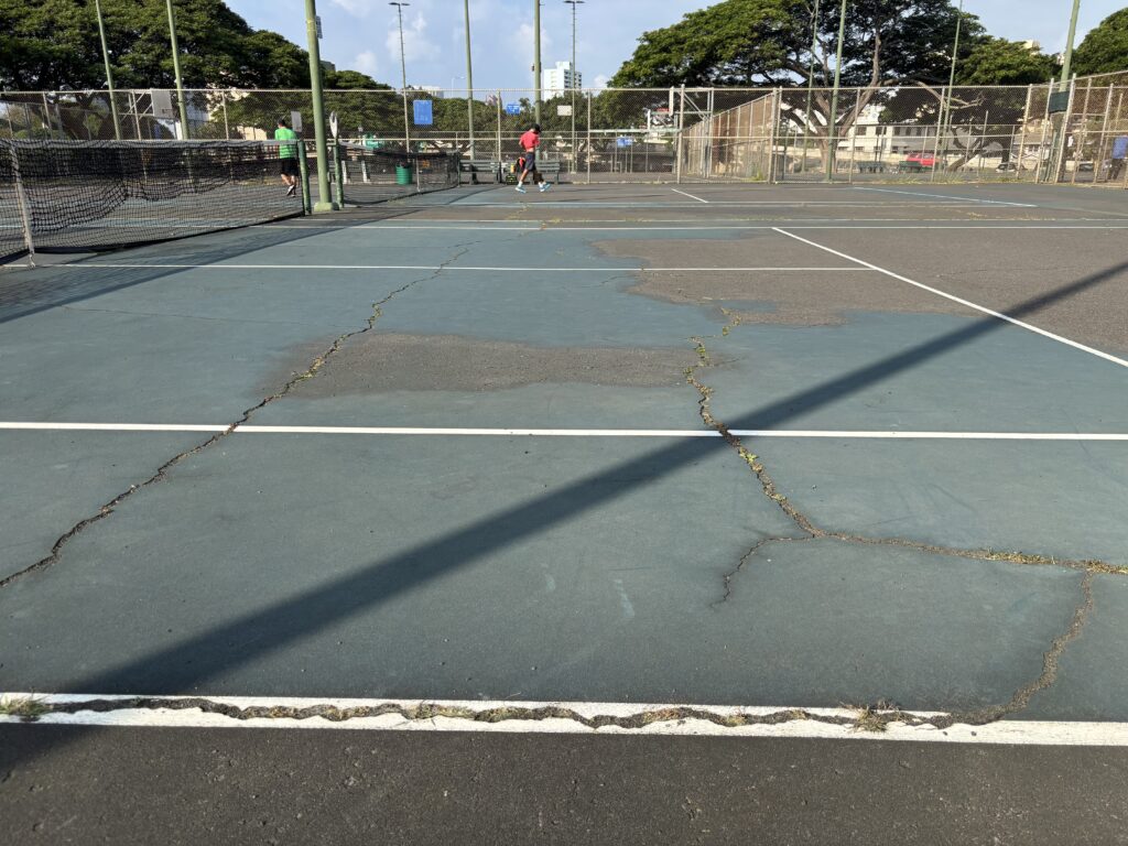 A cracked tennis court at Makiki District Park