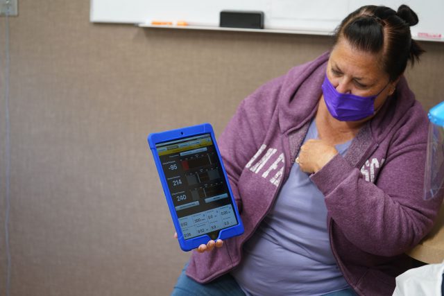 Kalani Pagan's wife Kim Pagan monitors the dialysis machine wirelessly with a tablet.