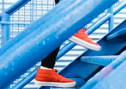 woman walking up blue steps