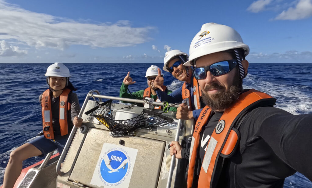 Reporter Nathan Eagle poses for a selfie with the NOAA crew aboard a safe boat in the open ocean.