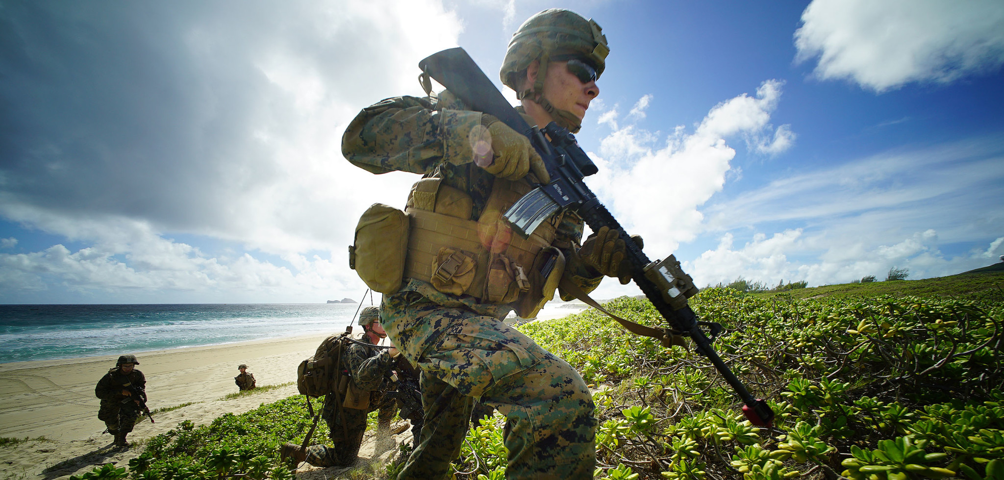 US Marines storm Pyramid Rock Beach Marine Corps Base Hawaii after landing on beach via Amphibious Assault Vehicles in RIMPAC exercises. Kaneohe Hawaii. 30 july 2016